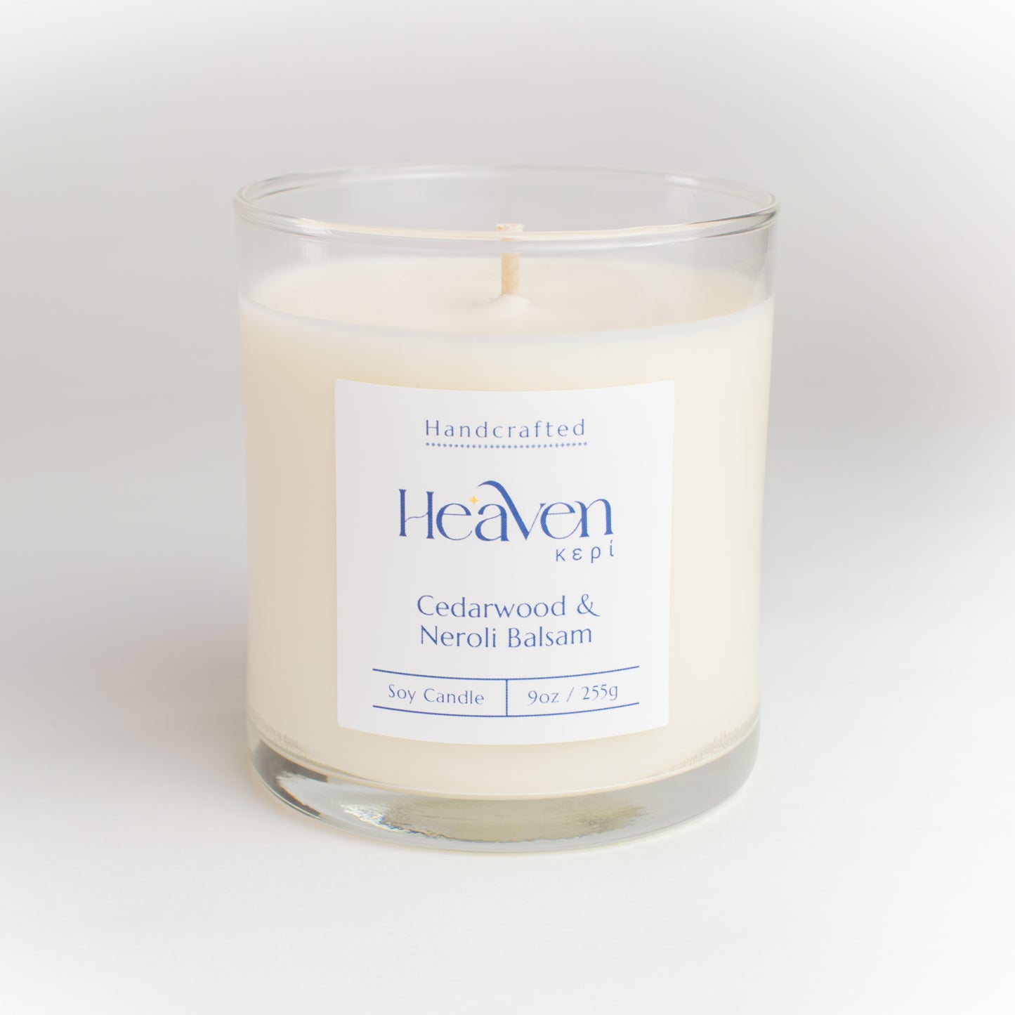 Candle displayed beside books, blankets, and soft lighting for cozy evening mood.