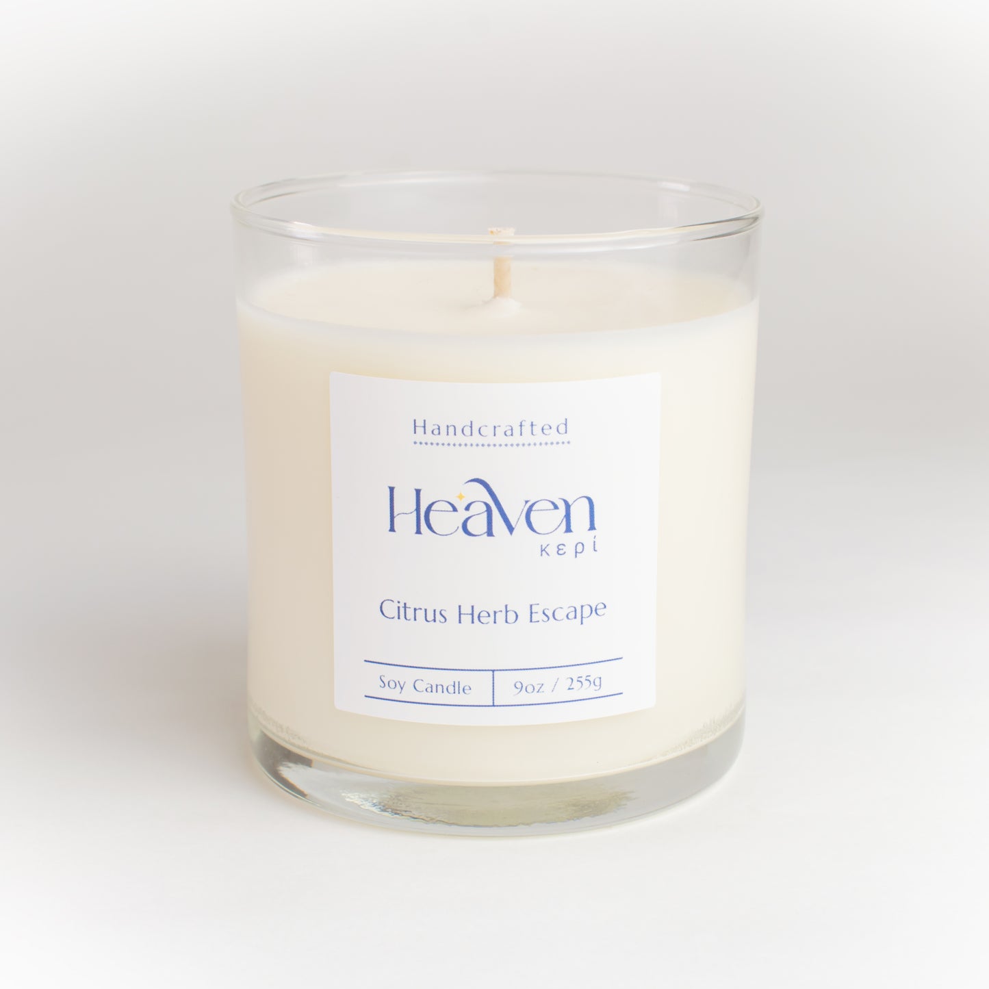 Soy candle on kitchen island with citrus fruits and fresh herbs for natural décor.